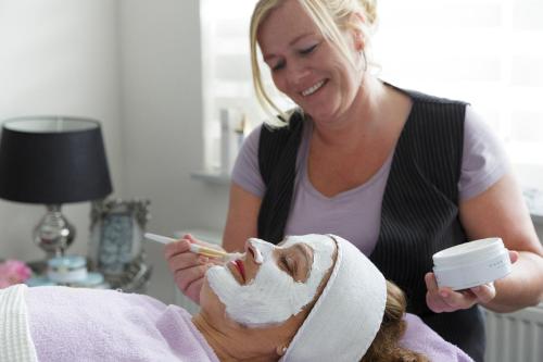 a woman shaving a mans face with a mask at Center Parcs Sandur Emmen in Emmen