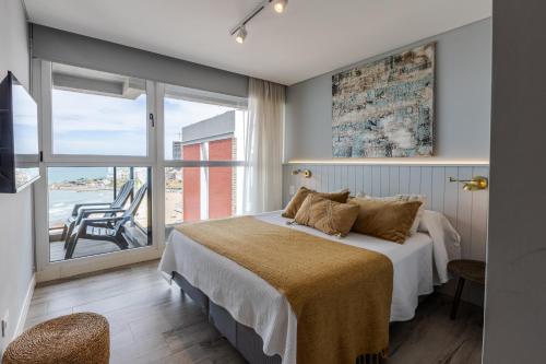 a bedroom with a bed with a view of the ocean at Residencias Roque Suarez in Mar del Plata