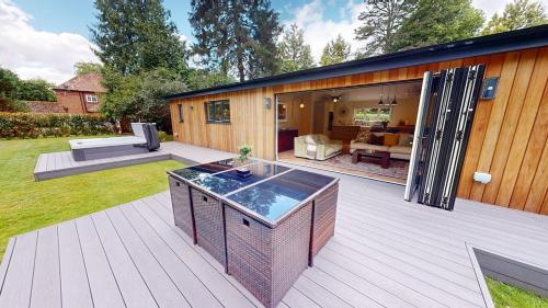 a patio with a koi pond on a deck at Hedgerows House New Forest in Ringwood