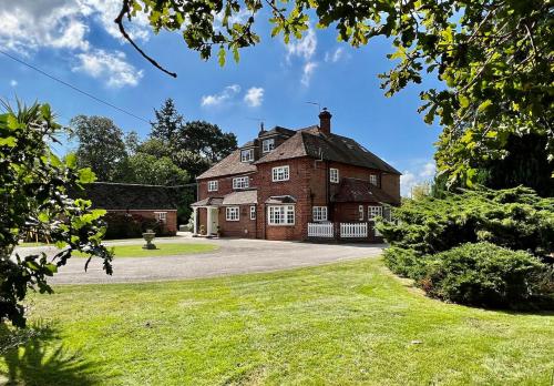 an old red brick house with a driveway at Hedgerows House New Forest in Ringwood