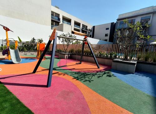 a playground with two swings on a colorful carpet at Boutique Loft, Stylish, Cozy and Luxurious style apartment in wonderful building with 2 Pools & Gym in Dubai