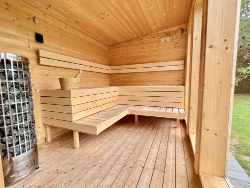 a wooden sauna with a bench on a wooden deck at Hedgerows House New Forest in Ringwood