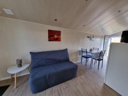un salon avec un canapé bleu et une table dans l'établissement Studio en plein cœur du bassin d'Arcachon, à Audenge