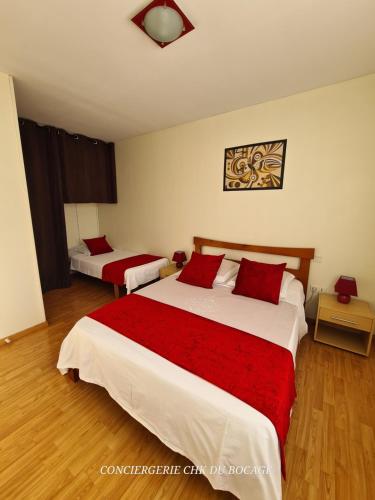 a bedroom with two beds with red pillows at Gîte le Vallon à Chambretaud, 5 min du Puy du Fou in Chambretaud