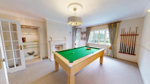 a room with a pool table and a fireplace at Hedgerows House New Forest in Ringwood