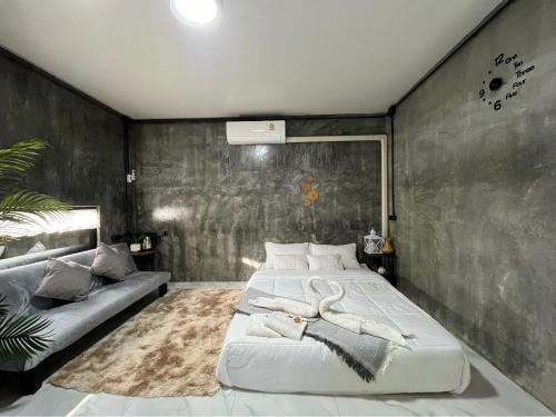a bedroom with a large bed and a couch at Missme Homestay-มิสมีโฮมสเตย์ in Ban Mae Na