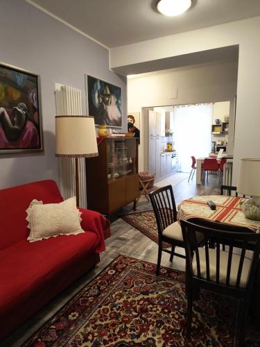 a living room with a red couch and a table at AppartamentoMonika con parcheggio privato - Volano in Volano