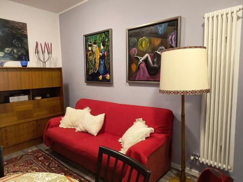 a living room with a red couch and a lamp at AppartamentoMonika con parcheggio privato - Volano in Volano