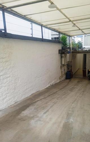 an empty room with a white wall and a concrete floor at Hotel + Arte in Quito