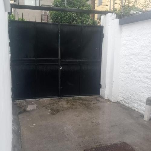 a black gate in front of a white wall at Hotel + Arte in Quito