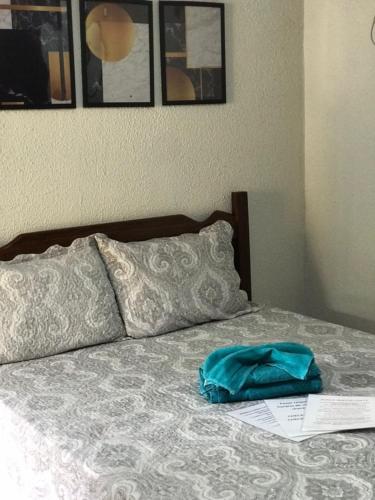 a bed with a blue bag on top of it at Suites Mar Azul Prainha in Arraial do Cabo
