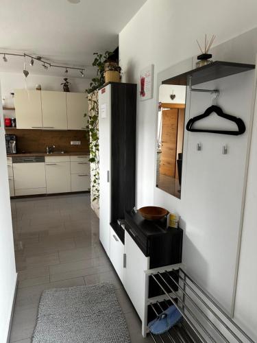 a kitchen with white cabinets and a black refrigerator at Ferienwohnung Mölltaler Bergblick in Obervellach