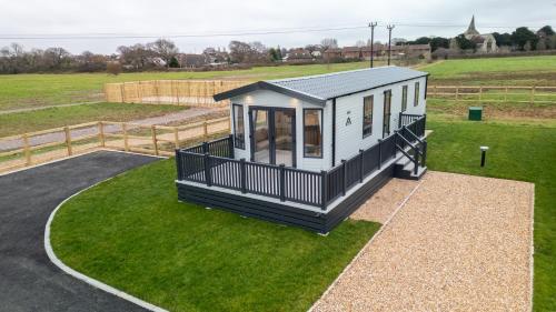 a tiny house sitting on top of a green field at Hayling Island Holiday Park in South Hayling