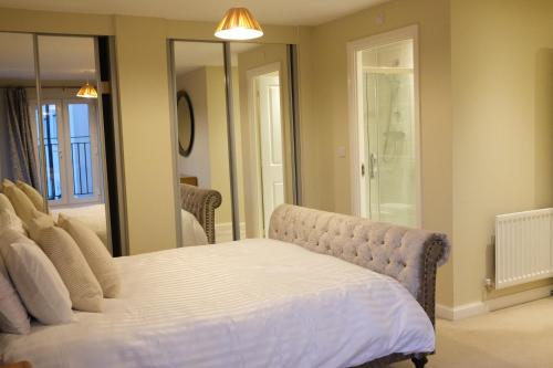 a bedroom with a bed and a mirror at Bicester Villa - 6 Bed - Sleeps 14 in Bicester