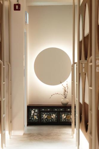 a hallway with a large round mirror in a room at D A L Premium Capsule Hotel in Seoul