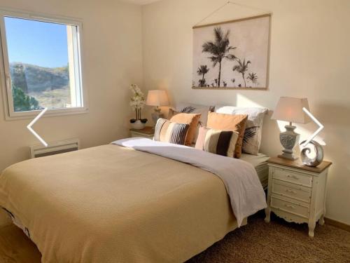 une chambre avec un lit avec deux lampes et une fenêtre dans l'établissement La Tranche sur mer 4 étoiles sea view, à La Tranche-sur-Mer