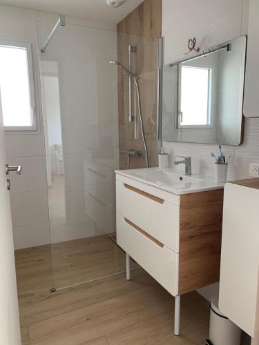 une salle de bain avec un lavabo blanc et une douche dans l'établissement La Tranche sur mer 4 étoiles sea view, à La Tranche-sur-Mer