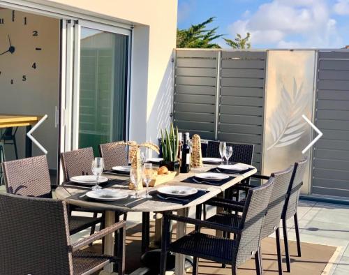 Une table à manger et des chaises sont disponibles sur la terrasse. dans l'établissement La Tranche sur mer 4 étoiles sea view, à La Tranche-sur-Mer