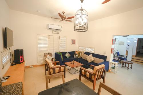 a living room with a blue couch and chairs at VILLA M - SOLITUDE 1 CANDOLIM GOA 3BHK, Pool Facing, Near Beach, Free Breakfast, Free WIFI and Prime Location in Candolim