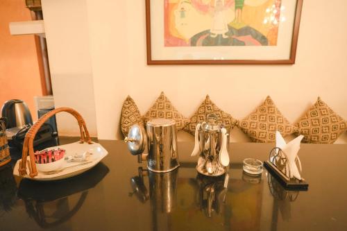 a table with some silver items on top of it at VILLA M - SOLITUDE 1 CANDOLIM GOA 3BHK, Pool Facing, Near Beach, Free Breakfast, Free WIFI and Prime Location in Candolim