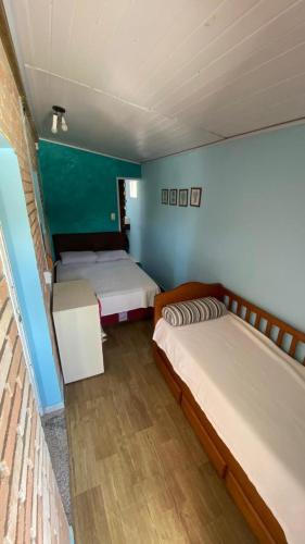 two beds in a room with green walls at Hostel Vento Leste in Bombinhas