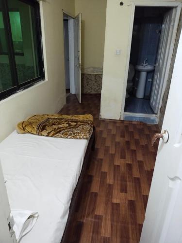 a bedroom with a bed and a wooden floor at Kashmir Continental Hotel Murree in Murree