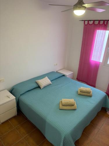 a bedroom with a blue bed with two towels on it at Heavenly Homes Mojacar 4 in Mojácar