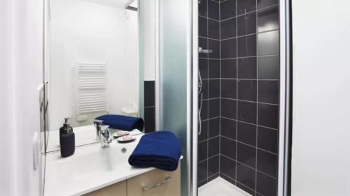 une salle de bain avec un lavabo et une douche dans l'établissement Studio moderne et privé, à Roubaix