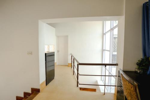 a hallway with stairs and a large window at VILLA M - SOLITUDE 2 CANDOLIM GOA 3BHK, Pool Facing, Near Beach, Free Breakfast, Free WIFI and Prime Location in Candolim