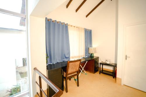 a room with a desk and a chair and a window at VILLA M - SOLITUDE 2 CANDOLIM GOA 3BHK, Pool Facing, Near Beach, Free Breakfast, Free WIFI and Prime Location in Candolim
