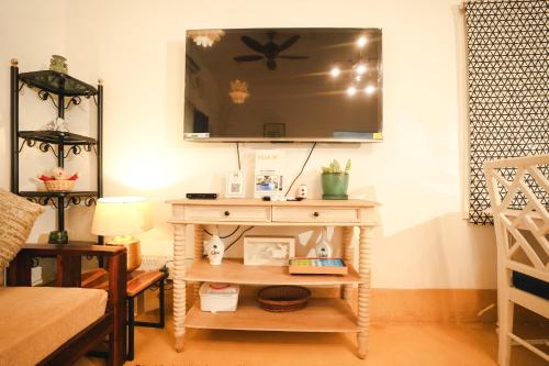 a living room with a table with a tv on the wall at VILLA M - SOLITUDE 2 CANDOLIM GOA 3BHK, Pool Facing, Near Beach, Free Breakfast, Free WIFI and Prime Location in Candolim