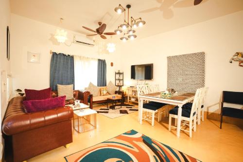 a living room with a couch and a table at VILLA M - SOLITUDE 2 CANDOLIM GOA 3BHK, Pool Facing, Near Beach, Free Breakfast, Free WIFI and Prime Location in Candolim
