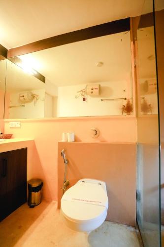 a bathroom with a white toilet in a room at VILLA M - SOLITUDE 2 CANDOLIM GOA 3BHK, Pool Facing, Near Beach, Free Breakfast, Free WIFI and Prime Location in Candolim