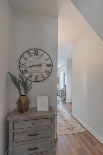 a clock on a wall above a dresser in a hallway at Loft On Landess in Marion