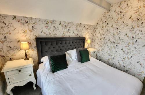 a bedroom with a bed with white sheets and green pillows at St George's Guest House in York