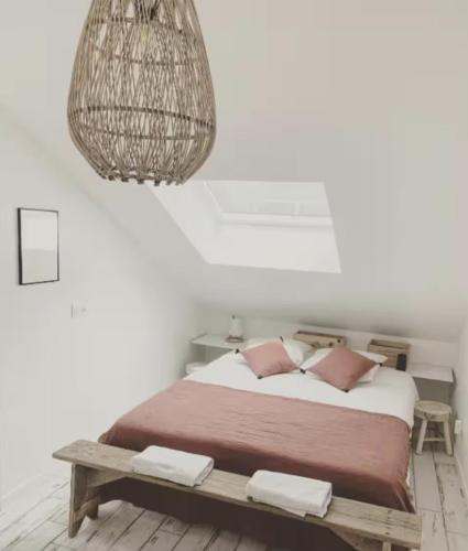 une chambre avec un grand lit et un lustre dans l'établissement Les Rotins - Appartements proches du centre-ville, à Reims