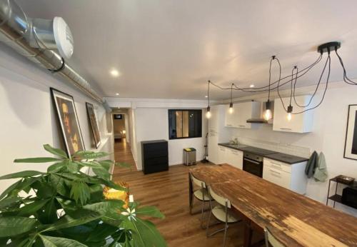 une cuisine et une salle à manger avec une table et une plante dans l'établissement Les Rotins - Appartements proches du centre-ville, à Reims