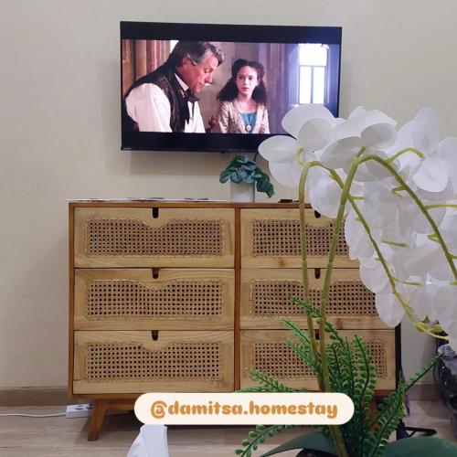 a tv on a wall above a dresser at Damitsa Homestay Syariah in Wonosobo