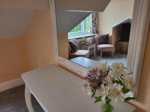 a vase of flowers on a table in a room at St George's Guest House in York