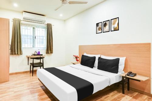 a hotel room with a large bed and a desk at Super Townhouse RR Nagar in Bengaluru