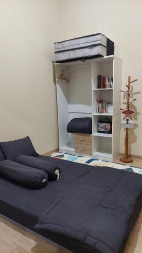 a bedroom with a bed and a book shelf at Damitsa Homestay Syariah in Wonosobo
