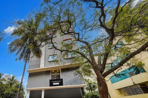 a building with a tree in front of it at Super Townhouse RR Nagar in Bengaluru