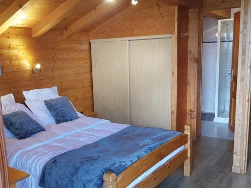 une chambre avec un lit dans une cabane en bois dans l'établissement Chalet individuel avec Wi-Fi, parking privé et animaux acceptés - FR-1-671-58, aux Gets