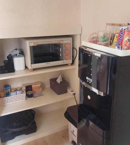 a kitchen with a microwave and a refrigerator at Damitsa Homestay Syariah in Wonosobo
