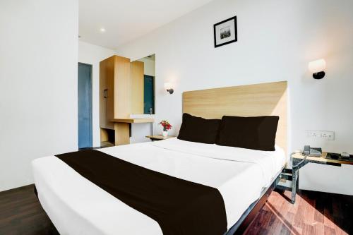 a bedroom with a large white bed in a room at Super Townhouse PBG Mall Vashi in Turambhe