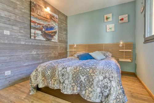 une chambre avec un lit et un mur en bois dans l'établissement Appart-terrasse , 80m de la plage Benoît, La BAULE, à La Baule