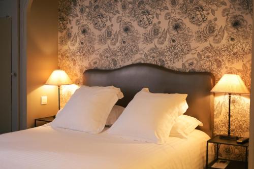 a bedroom with a white bed with two lamps at Best Western Plus d'Europe et d'Angleterre in Mâcon