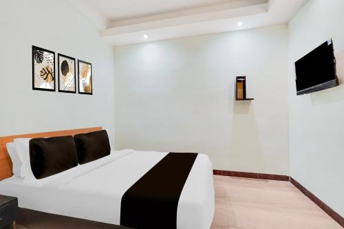 a white bedroom with a black and white bed at Super Hotel O Upper Bazar formerly RR Residency in Rānchī