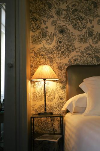 a lamp on a side table next to a bed at Best Western Plus d'Europe et d'Angleterre in Mâcon