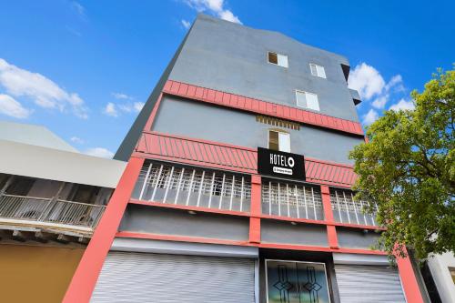 a tall building with red and gray at Super Hotel O Upper Bazar formerly RR Residency in Rānchī